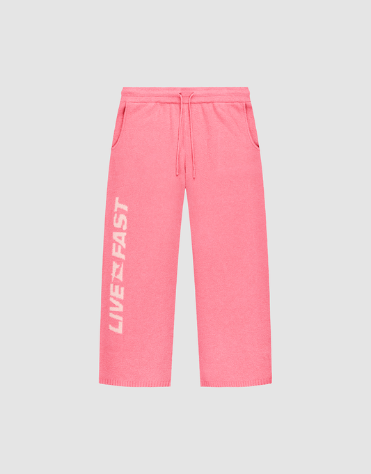The Live Fast Boucle Pants by LIVE FAST DIE YOUNG feature a bright pink wide fit, elastic waistband, side pockets, and “LIVE FAST” in bold white text vertically on the left leg. | plain