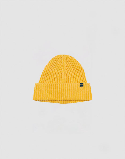 A yellow LFDY Washed Rib Knit Beanie with a folded brim and a small blue rectangular tag on the front, shown against a plain light gray background.