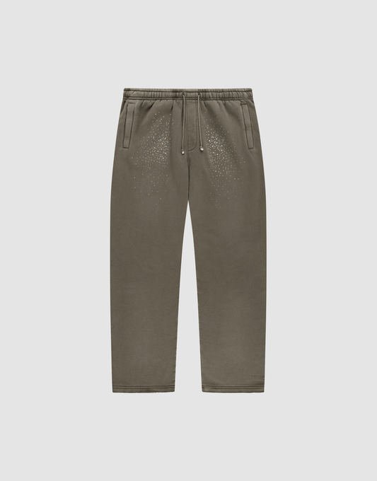 The LIVE FAST DIE YOUNG Live Fast Rhinestone Jogger, in olive green with an elastic waistband, drawstring, side pockets, and rhinestone detail, is shown laid flat on a plain light gray background. | plain