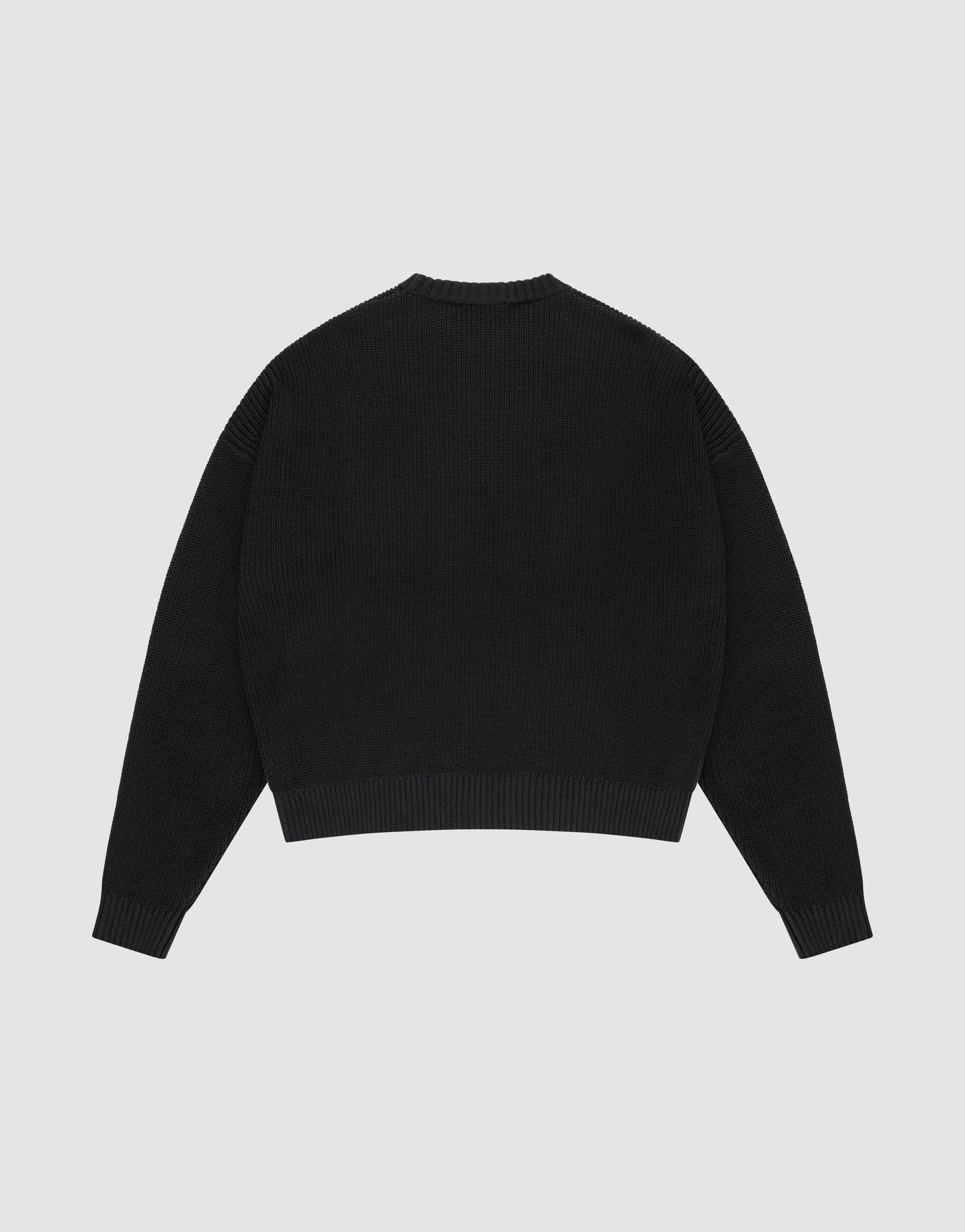The LFDY Knit Sweater by LIVE FAST DIE YOUNG is a plain black, oversized long-sleeve with a crew neckline, dropped shoulders, and ribbed cuffs and hem. Made from 100% Baumwolle, it's shown laid flat back-up on a light gray background.