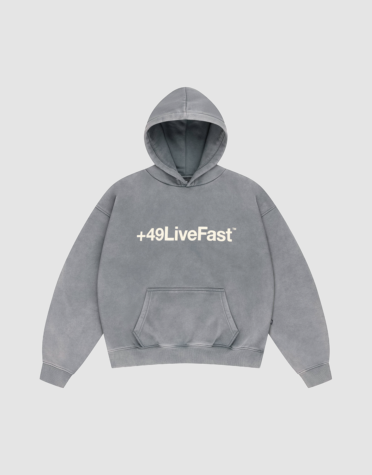 The LIVE FAST DIE YOUNG Basic +49 Hooded is a gray, oversized cotton hoodie with a white "+49LiveFast™" front print, hood, and front pocket, shown laid flat on a light gray background.