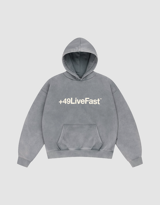 The LIVE FAST DIE YOUNG Basic +49 Hooded is a gray, oversized cotton hoodie with a white "+49LiveFast™" front print, hood, and front pocket, shown laid flat on a light gray background. | plain