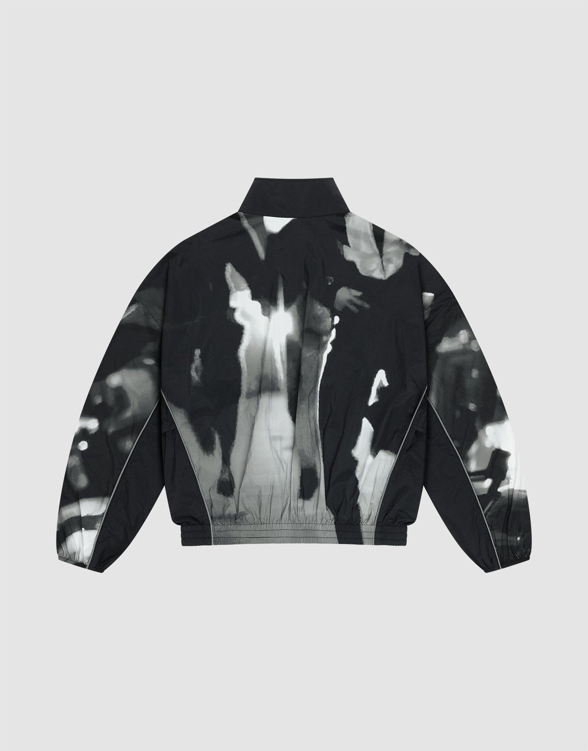 The LFDY Performance Jacket by LIVE FAST DIE YOUNG is a black nylon piece with long sleeves, a collar, and an abstract high-contrast black and white print of blurred human figures on the back, shown on a plain light gray background.