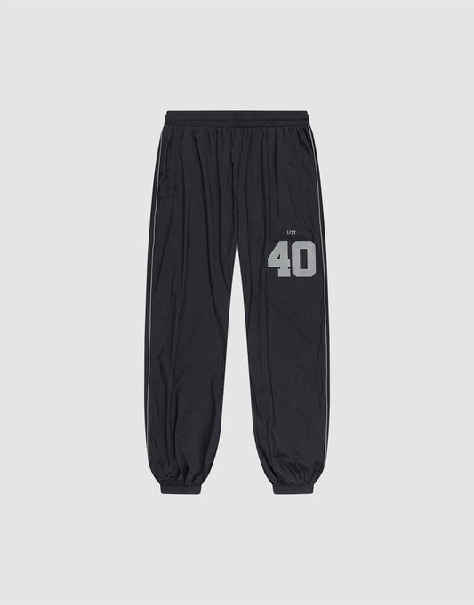 LFDY Performance Trackpants by LIVE FAST DIE YOUNG in black, with elastic waistband and cuffs. Gray reflective "40" and brand print on left thigh, oversize fit. Shown on a plain light gray background. | plain