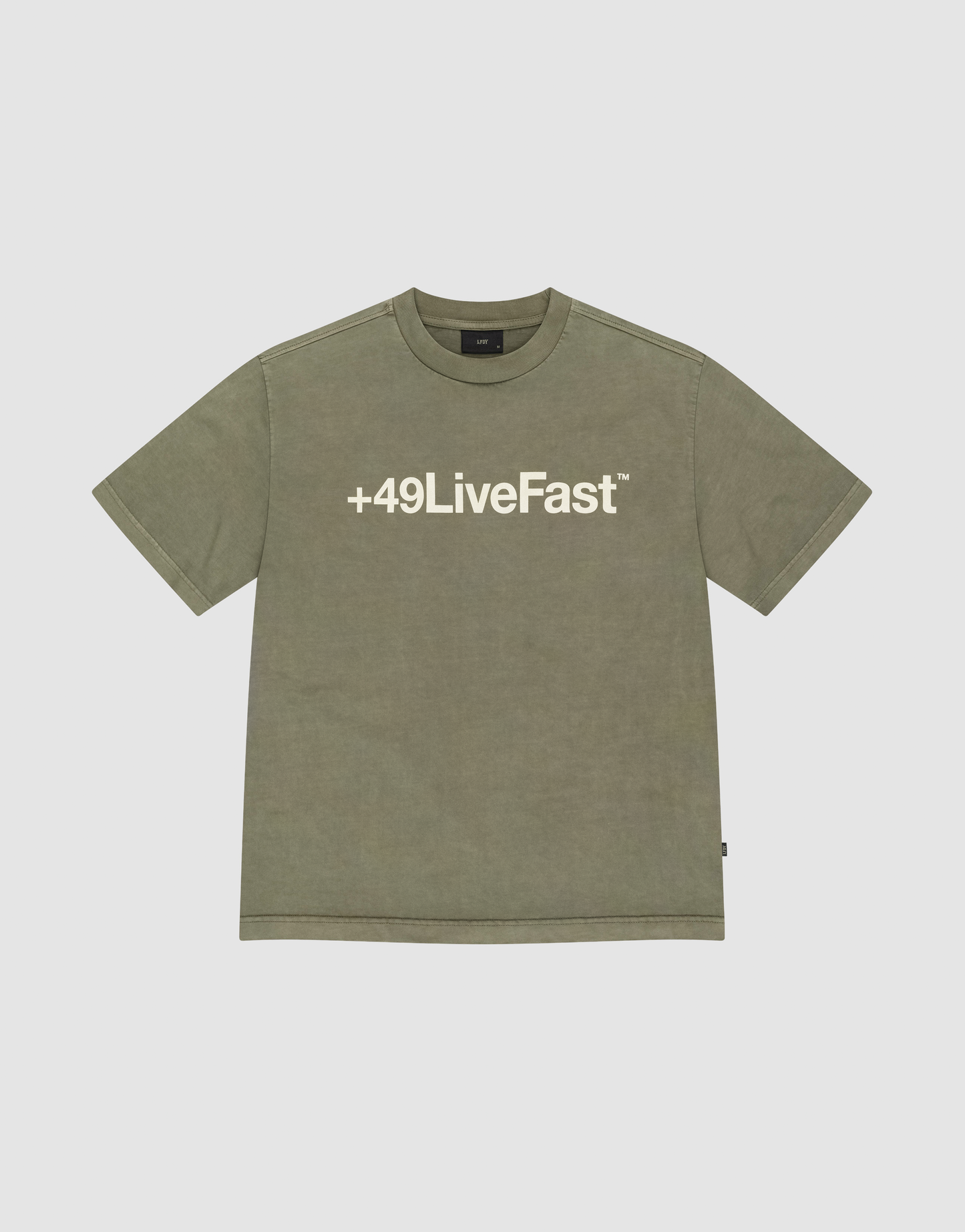 The Basic +49 Tee by LIVE FAST DIE YOUNG is an olive green, oversize short-sleeve T-shirt with a bold white +49LiveFast™ front print, made from 100% Baumwolle and shown on a plain light grey background. | plain