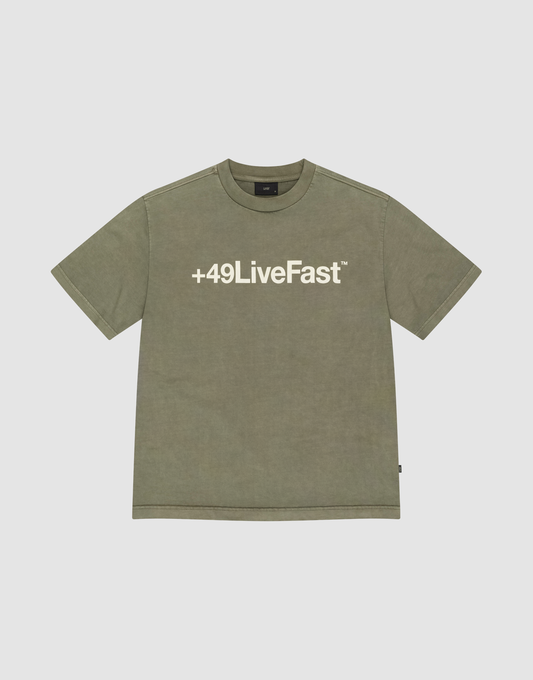 The Basic +49 Tee by LIVE FAST DIE YOUNG is an olive green, oversize short-sleeve T-shirt with a bold white +49LiveFast™ front print, made from 100% Baumwolle and shown on a plain light grey background. | plain