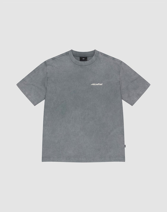 The LIVE FAST DIE YOUNG Basic +49 Chest Tee is a grey, oversized short-sleeve t-shirt with a round neck and a small white “+49” logo on the left chest. Made from 100% Baumwolle, shown on a light grey background. | plain