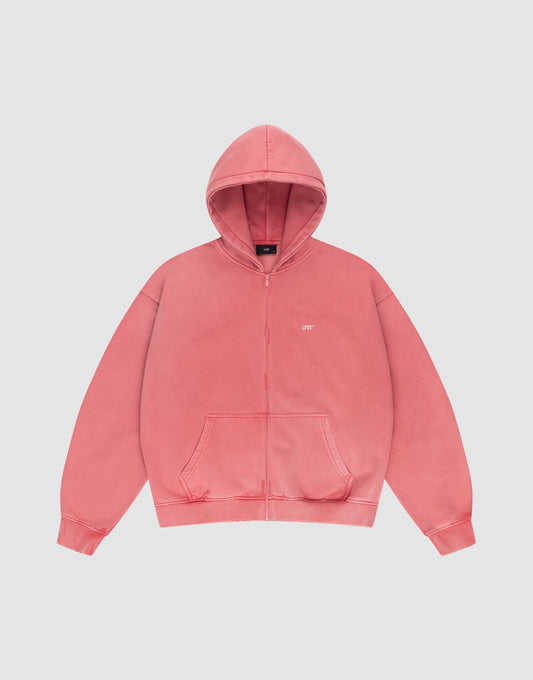 The LIVE FAST DIE YOUNG Basic Hooded Zip is a coral pink oversized zip-up hoodie with front pockets, a hood, and small white UPT text on the left chest, displayed on a plain white background.