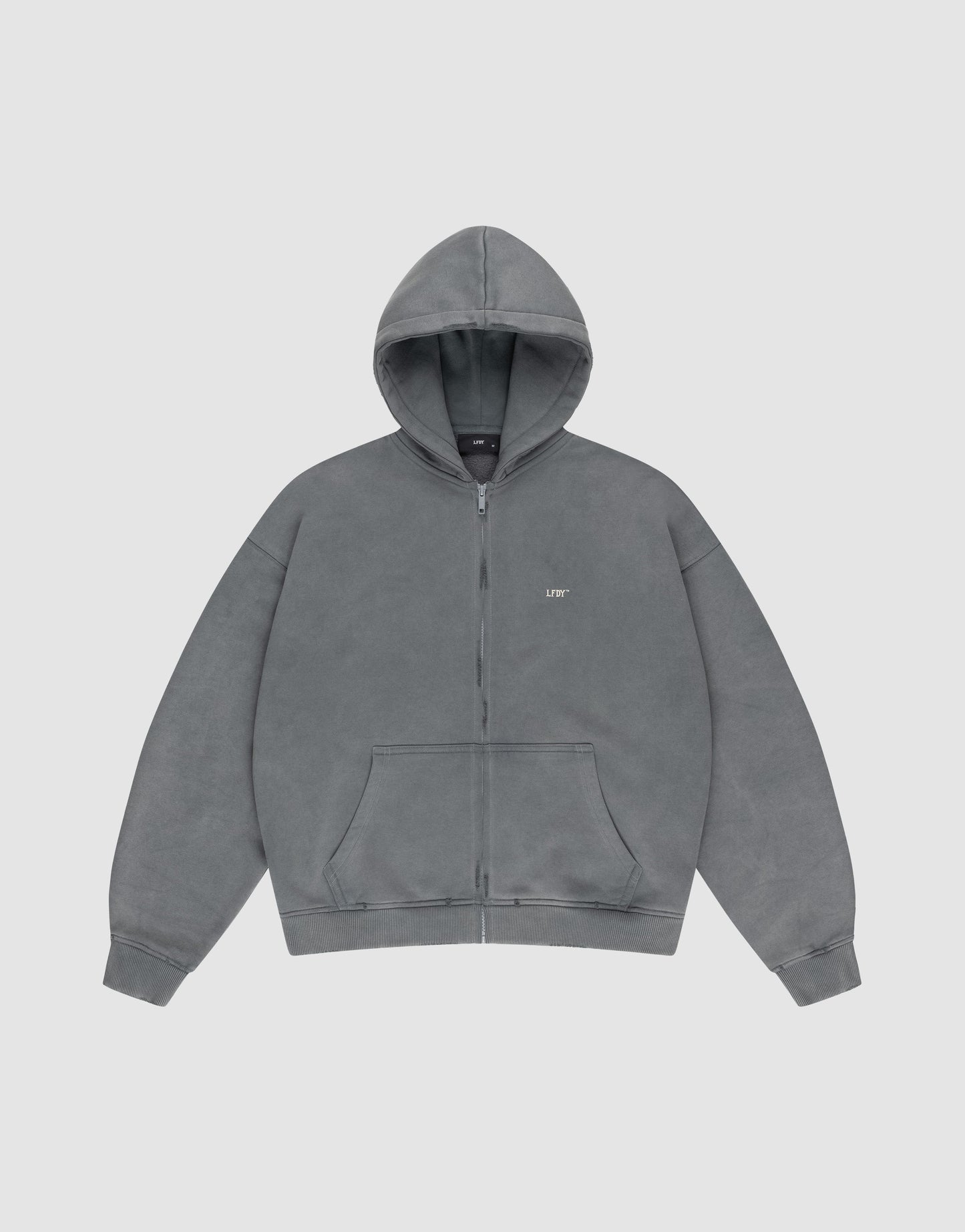 The LIVE FAST DIE YOUNG Basic Hooded Zip is a plain gray oversized hoodie with a zip front, hood, front pockets, and a subtle white “LIFT” logo on the left chest, shown against a light gray background.