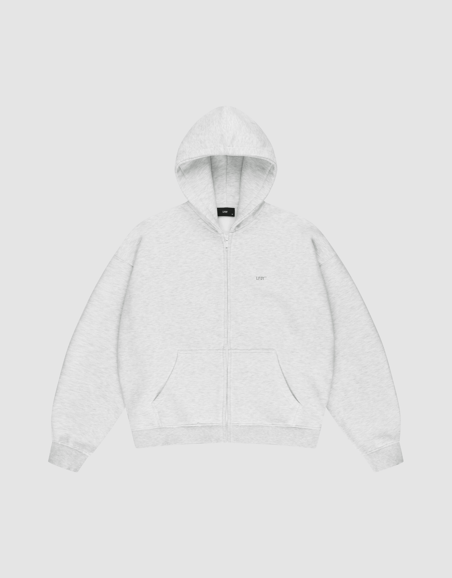 The LIVE FAST DIE YOUNG Basic Hooded Zip is a light gray zip-up hoodie with an oversize fit, front pockets, and a hood. It features subtle LFDY branding on the chest and is shown laid flat on a plain white background. | plain