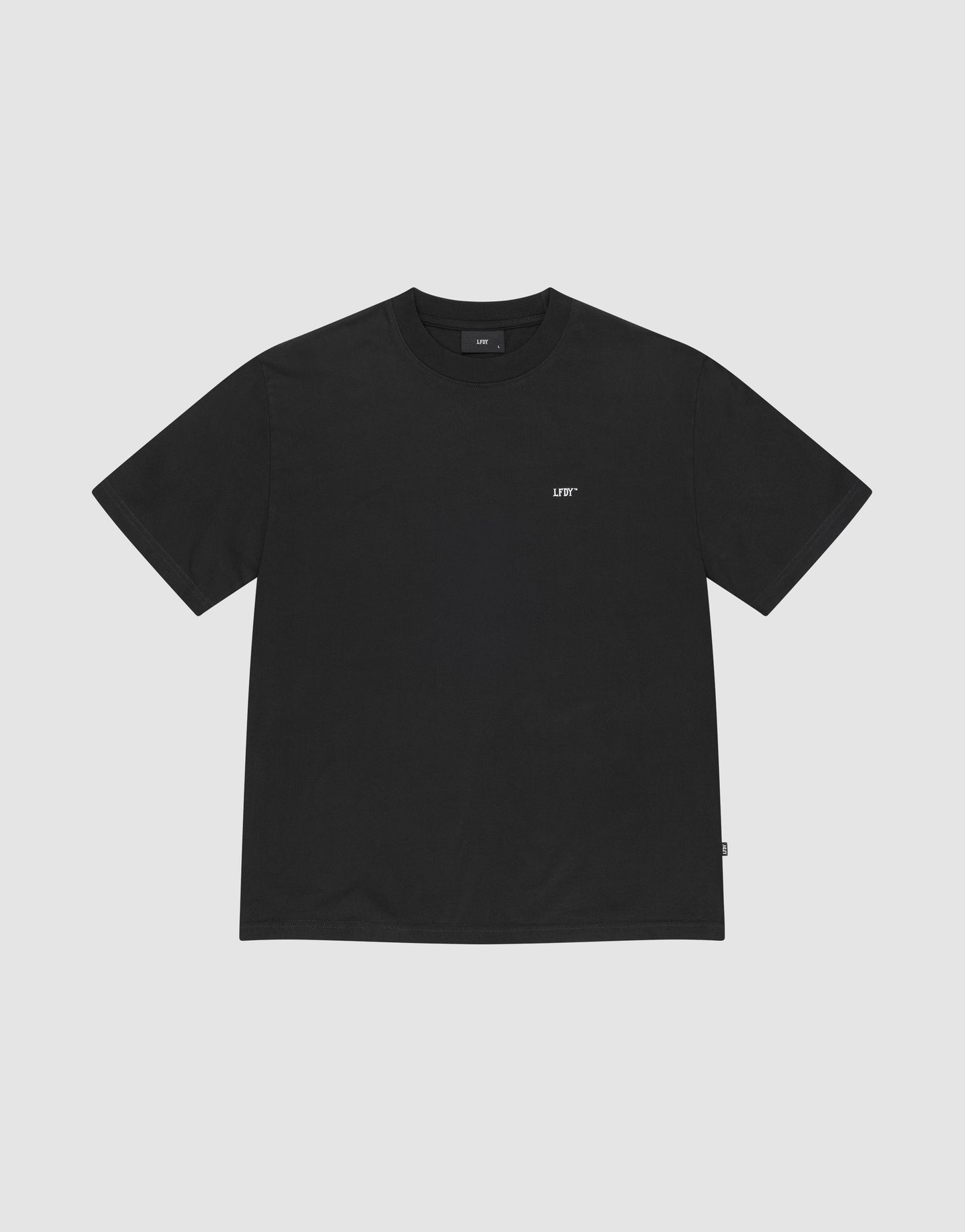 The Basic Chest Tee by LIVE FAST DIE YOUNG is a plain black regular fit, short-sleeve t-shirt in 100% cotton, featuring a small white LIFT logo below the collar. The shirt is displayed flat on a light gray background.