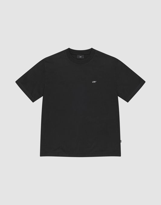 The Basic Chest Tee by LIVE FAST DIE YOUNG is a plain black regular fit, short-sleeve t-shirt in 100% cotton, featuring a small white LIFT logo below the collar. The shirt is displayed flat on a light gray background. | plain