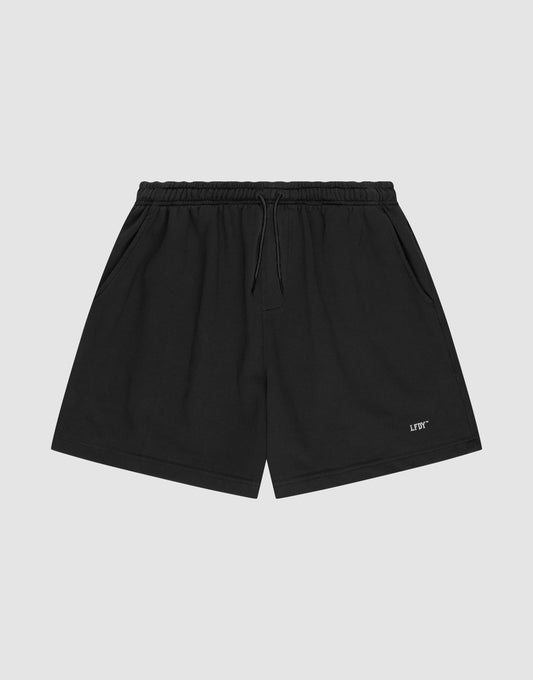 LIVE FAST DIE YOUNG Basic Sweat Shorts in plain black, featuring an elastic waistband, drawstring, side pockets, and a small white logo print on the left leg, shown on a light gray background. | plain