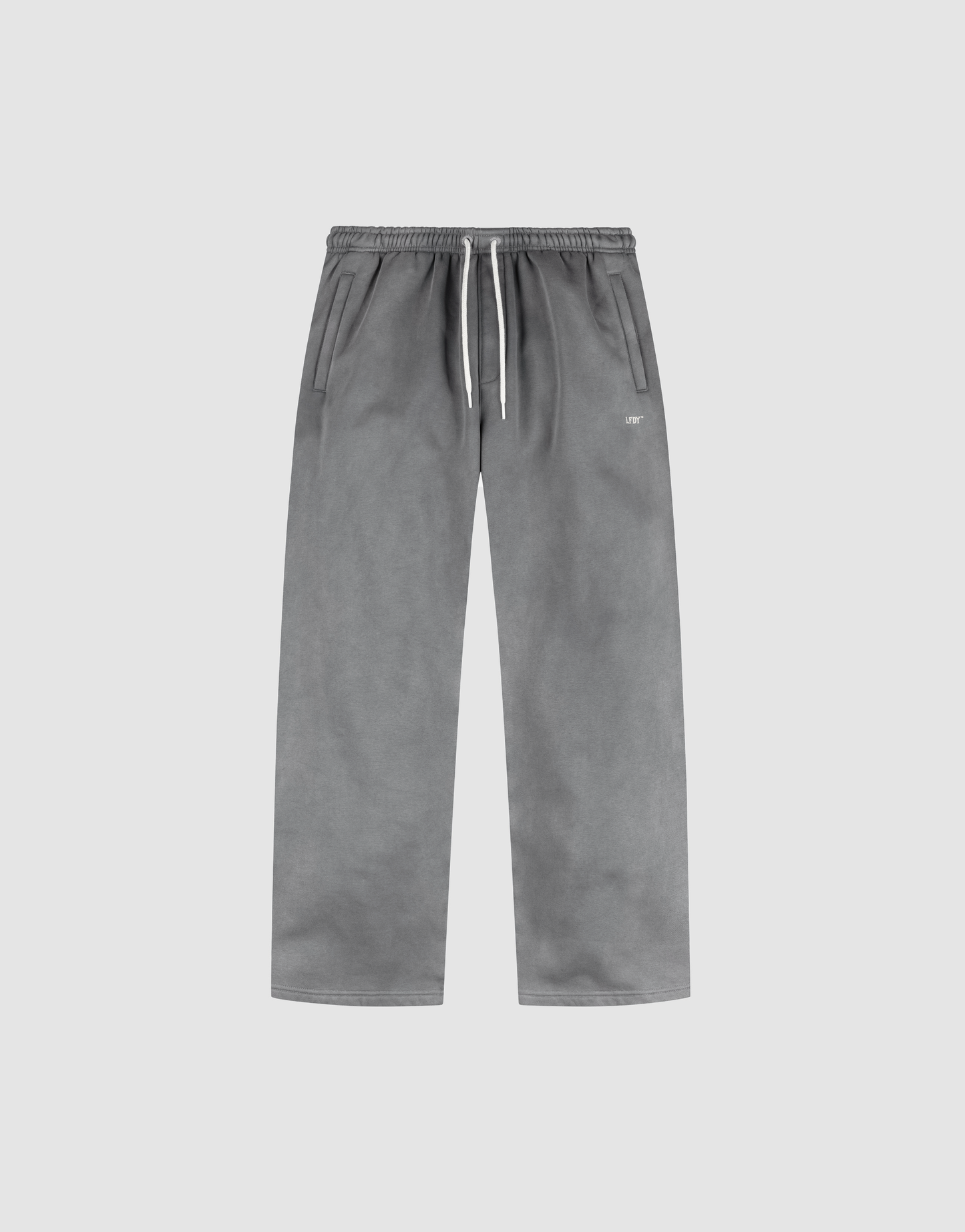 The LIVE FAST DIE YOUNG Basic Wide Jogger features a grey oversized straight-leg design with an elastic waistband, white drawstring, side pockets, and subtle logo print, shown on a plain light background.