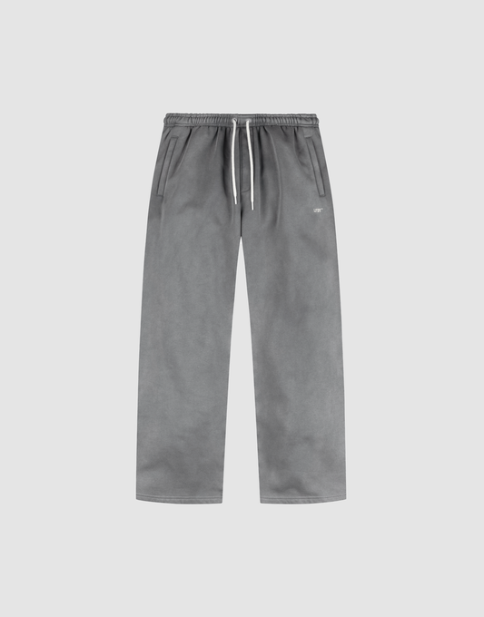 The LIVE FAST DIE YOUNG Basic Wide Jogger features a grey oversized straight-leg design with an elastic waistband, white drawstring, side pockets, and subtle logo print, shown on a plain light background.