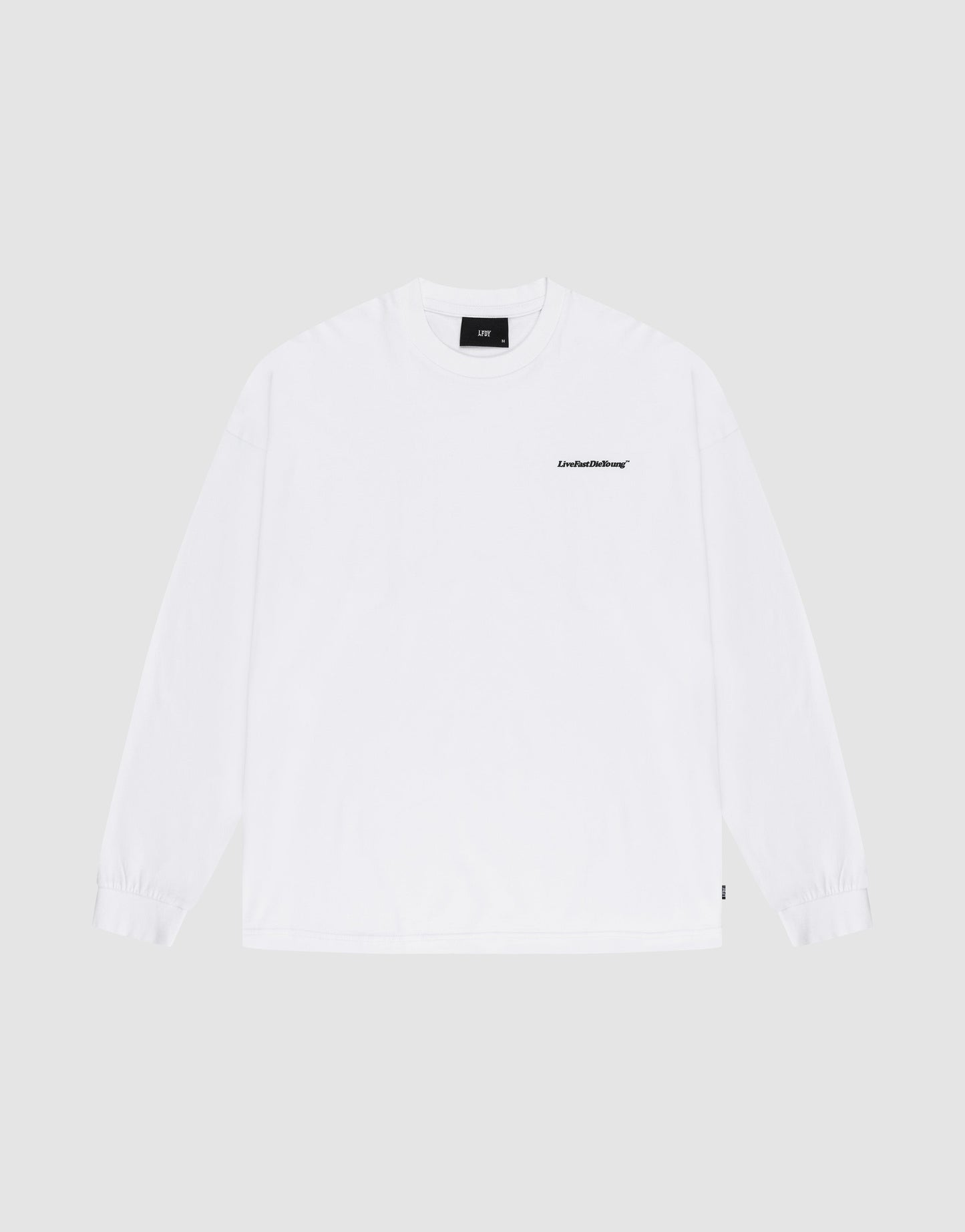 The Basic Longsleeve by LIVE FAST DIE YOUNG is an oversize white 100% Baumwolle T-shirt with a small black logo-print on the left chest, shown against a light gray background. | plain