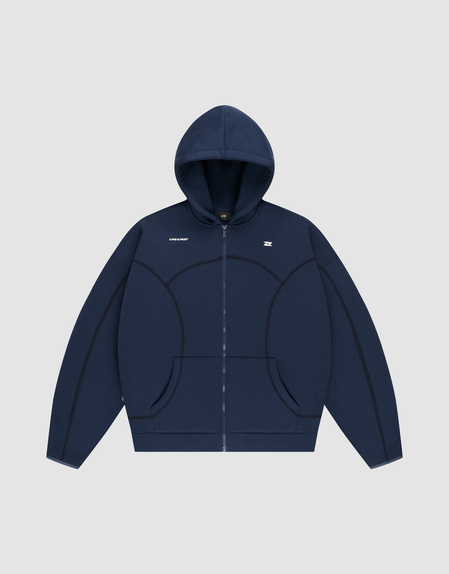 The LFDY Active Fleece Hooded Zip by LIVE FAST DIE YOUNG is a navy blue oversized zip-up hoodie with a hood, front pockets, curved seam details, and small white chest logo. Made from soft Baumwolle for comfort. Photographed on a light gray background.