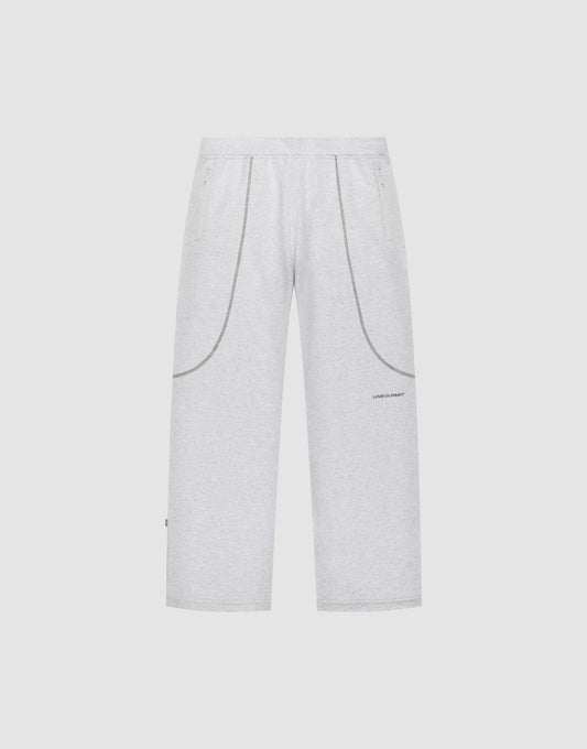The LFDY Active Fleece Jogger by LIVE FAST DIE YOUNG features a wide fit, light gray color, elastic waistband, two side pockets, curved seam details, and a small logo print on the left thigh, shown on a plain white background. | plain