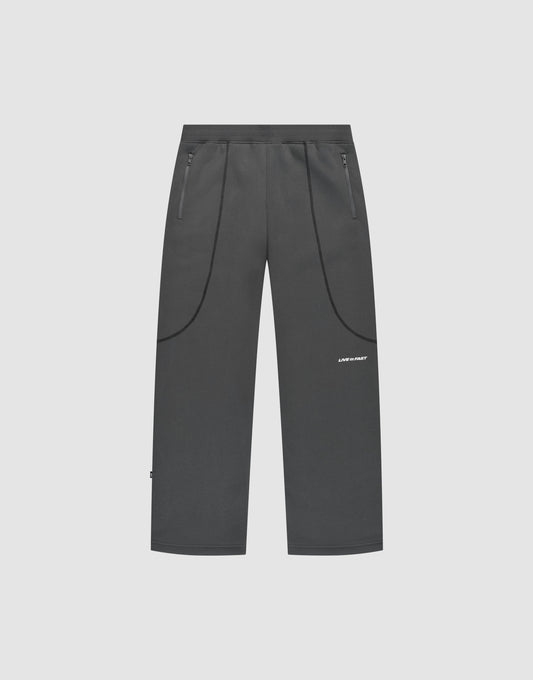 Dark gray LFDY Active Fleece Jogger by LIVE FAST DIE YOUNG featuring a wide fit, straight-leg design, zippered side pockets, curved seam details, and a small white logo on the upper left thigh, shown on a plain light background. | plain