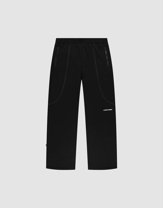The LFDY Active Fleece Jogger by LIVE FAST DIE YOUNG features a black wide fit, straight-leg design with zip pockets and a small white logo print on the left thigh, displayed on a plain light gray background. | plain