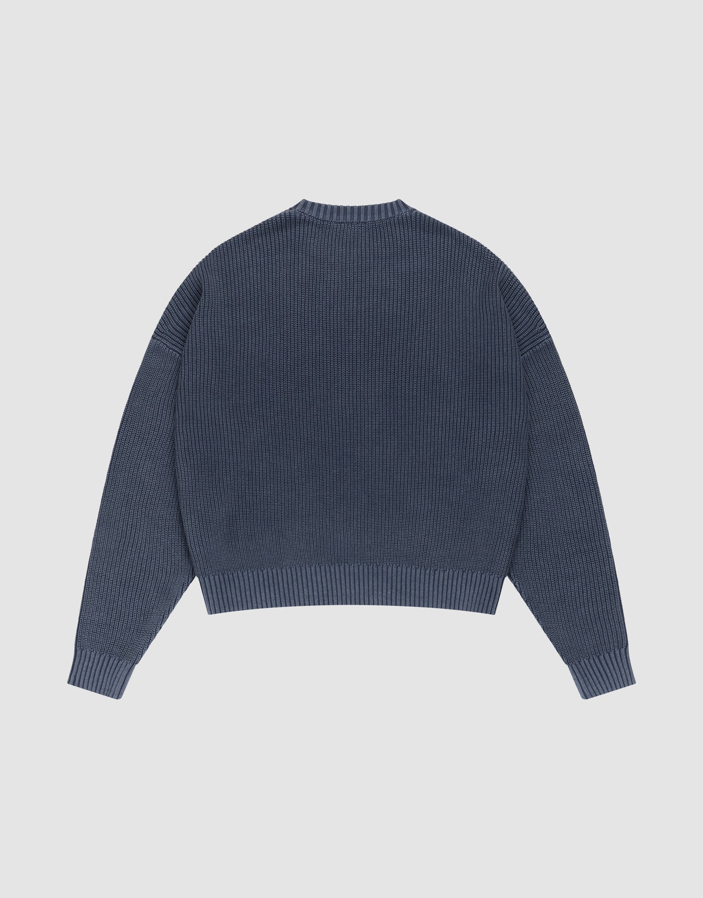 The LFDY Knit Sweater by LIVE FAST DIE YOUNG is shown laid flat from the back. This blue oversized ribbed knit features long sleeves with dropped shoulders, a round neckline, and a straight hem. | plain