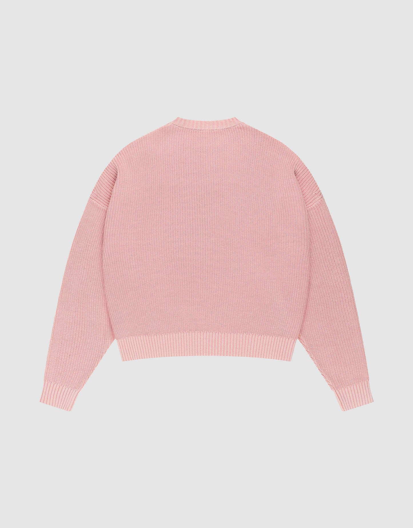 The LFDY Knit Sweater by LIVE FAST DIE YOUNG, in light pink with long sleeves, ribbed knit, oversized fit, and dropped shoulders, is laid flat on a plain white background with the back facing up.
