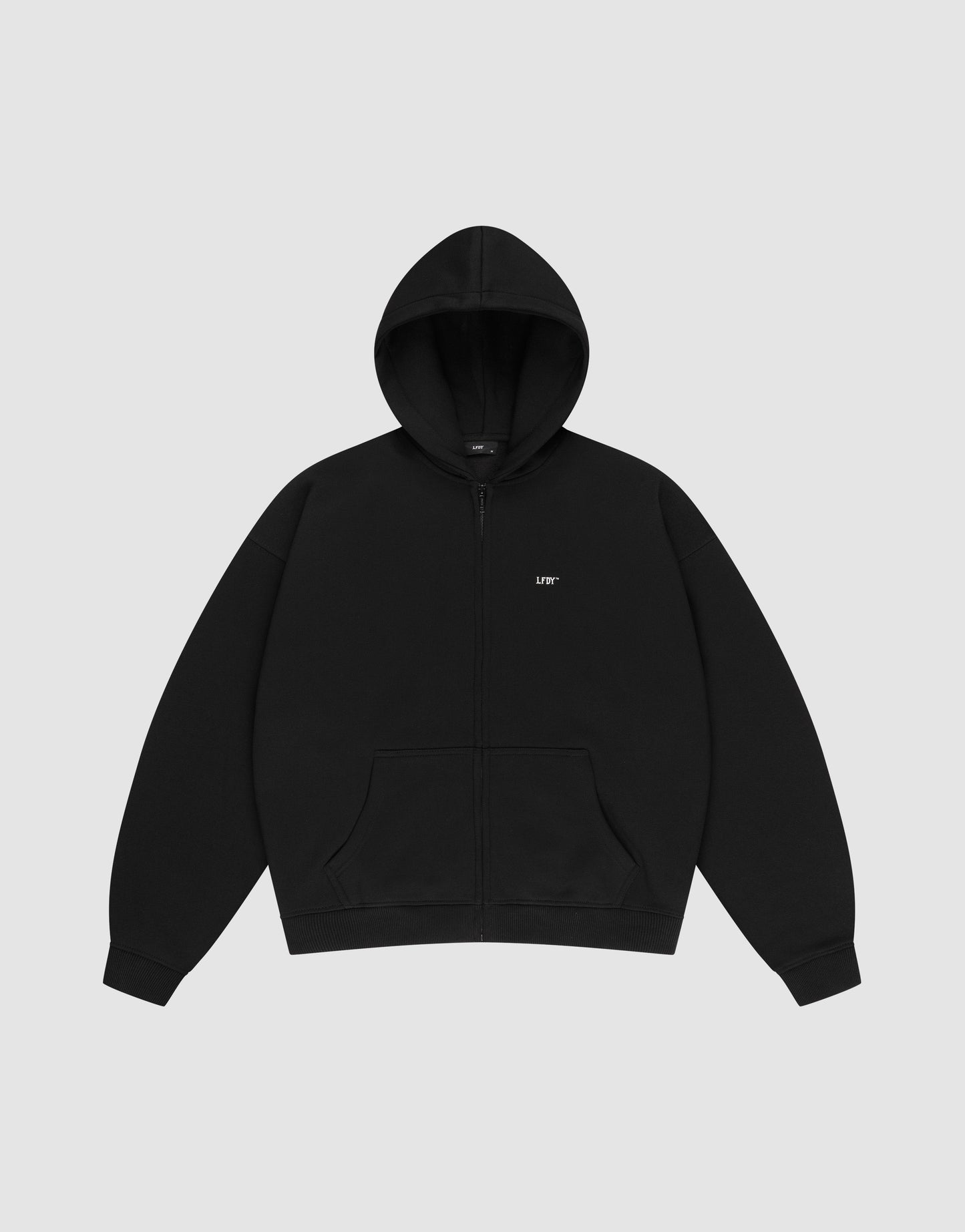 The LIVE FAST DIE YOUNG Basic Hooded Zip is a plain black zip-up hoodie with a hood, front pockets, an oversize fit, and a small white LIFT logo on the left chest, shown laid flat on a light gray background.