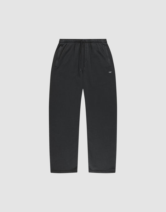 LIVE FAST DIE YOUNG Basic Wide Jogger: black sweatpants with drawstring waist, side pockets, wide fit, and a small white logo on the left thigh. Shown on a plain light gray background. | plain