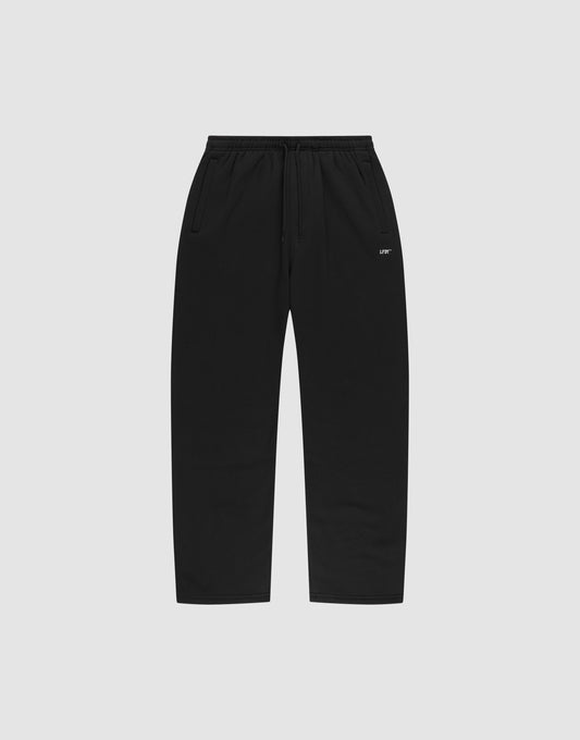 The LIVE FAST DIE YOUNG Basic Wide Jogger features black straight-leg sweatpants with an elastic waistband, drawstring, side pockets, and a small white logo print near the left pocket, shown on a plain light gray background. | plain