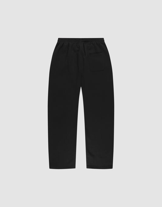 The LIVE FAST DIE YOUNG Basic Wide Jogger in black, designed with an oversized fit, elastic waistband, and single back pocket, is laid flat on a plain light grey background.