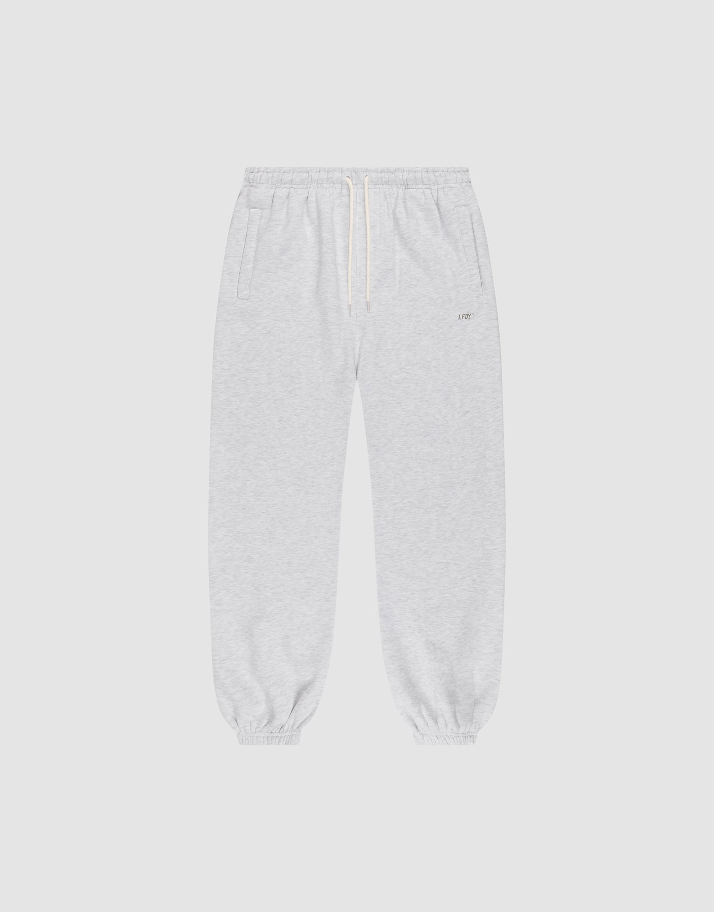 The LIVE FAST DIE YOUNG Basic Loose Jogger features light gray fabric, an Elastik-Bund waistband with white drawstring, side pockets, and elastic cuffs. The soft material and loose fit offer comfort for casual or athletic wear.