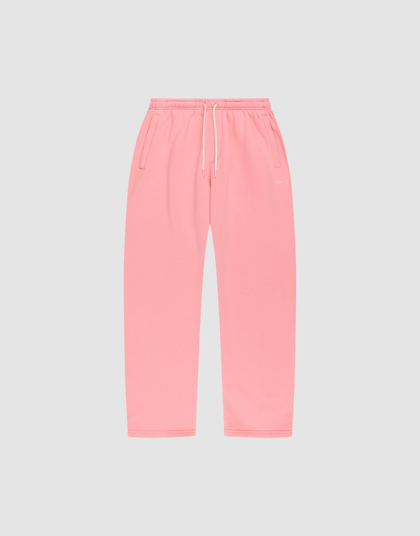 The Basic Wide Jogger by LIVE FAST DIE YOUNG features an oversized fit, elastic waistband, white drawstring, and side pockets, shown in pink laid flat on a light gray background.