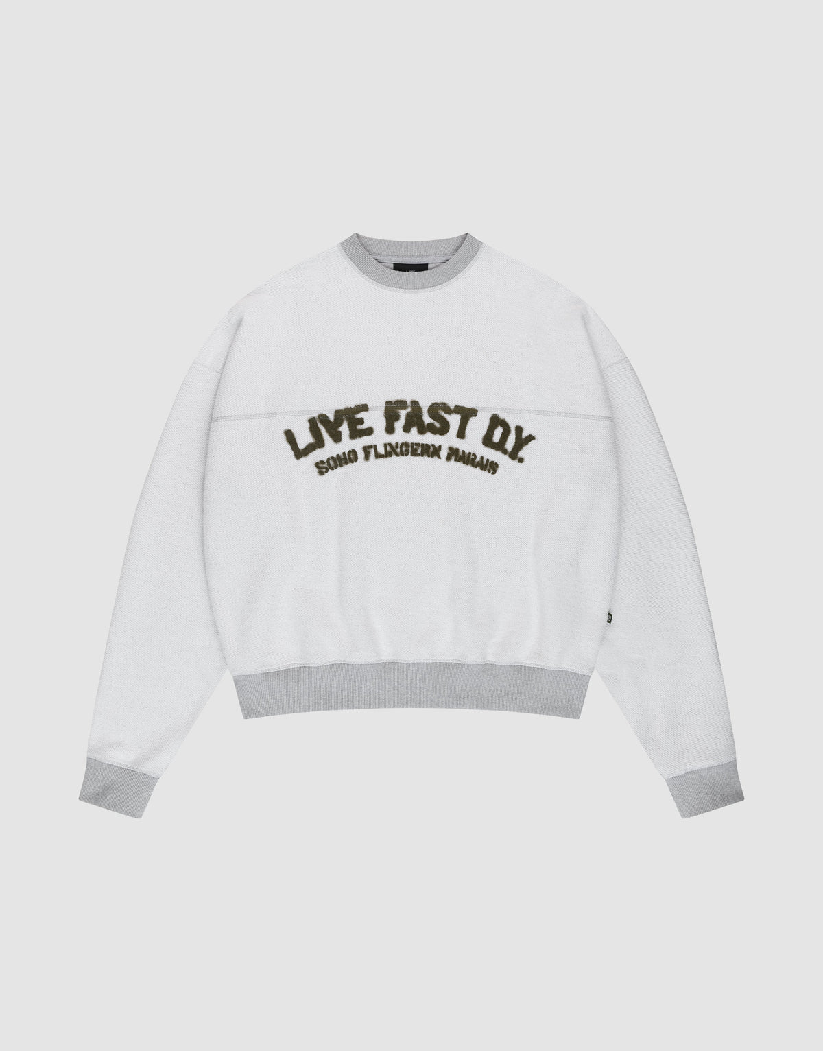 The LFDY District Sweater by LIVE FAST DIE YOUNG is a white oversized crewneck with light gray collar, cuffs, and hem in 480 GSM inside-out fabric. The chest displays bold LIVE FAST D.I.Y. text above ROAD FLECHTERIN PARADIS. | plain