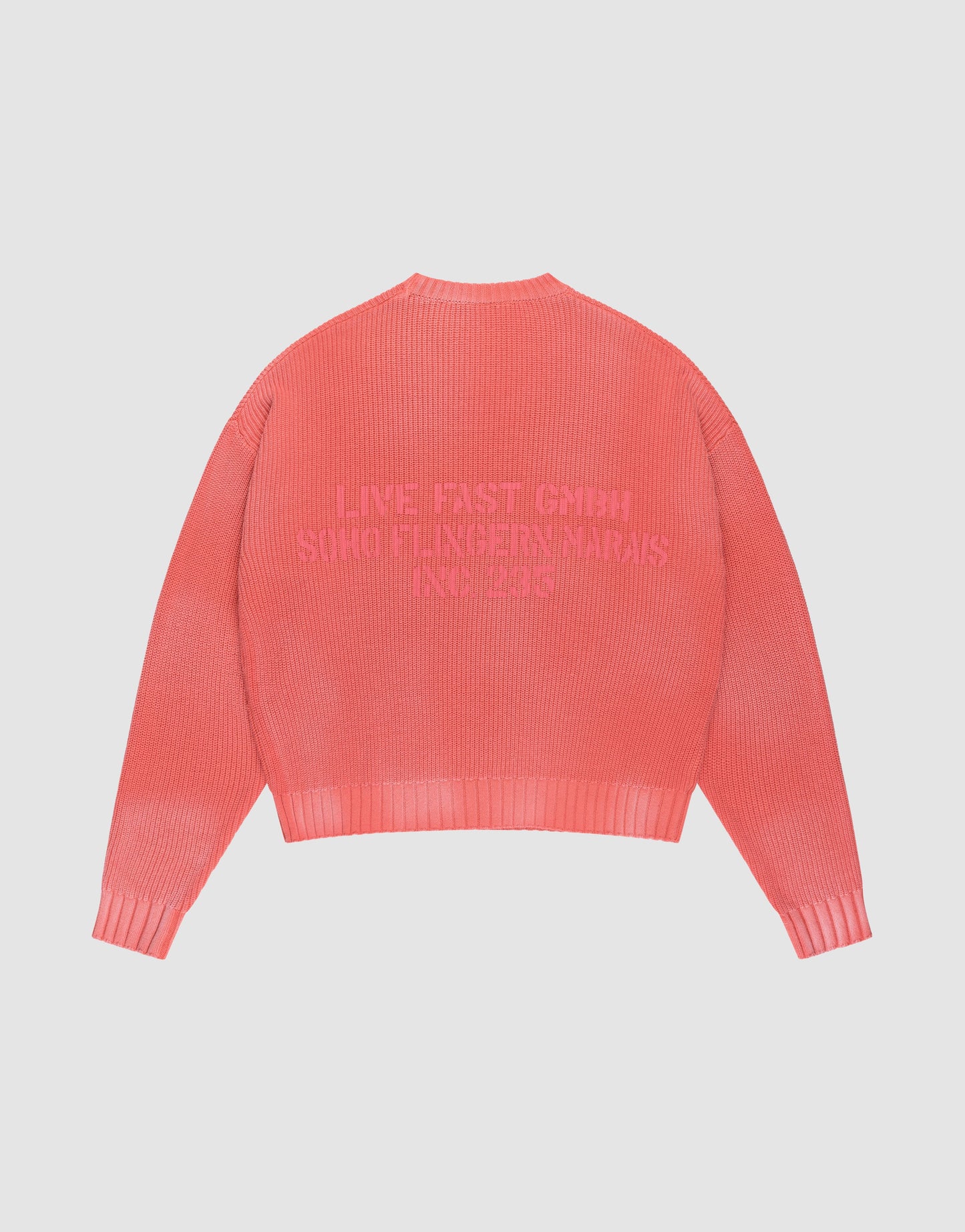 The LFDY Washed Knit Sweater by LIVE FAST DIE YOUNG is a coral pink ribbed knit with an oversize fit, long sleeves, and embossed backprint text in a darker hue. Made from 100% Baumwolle.