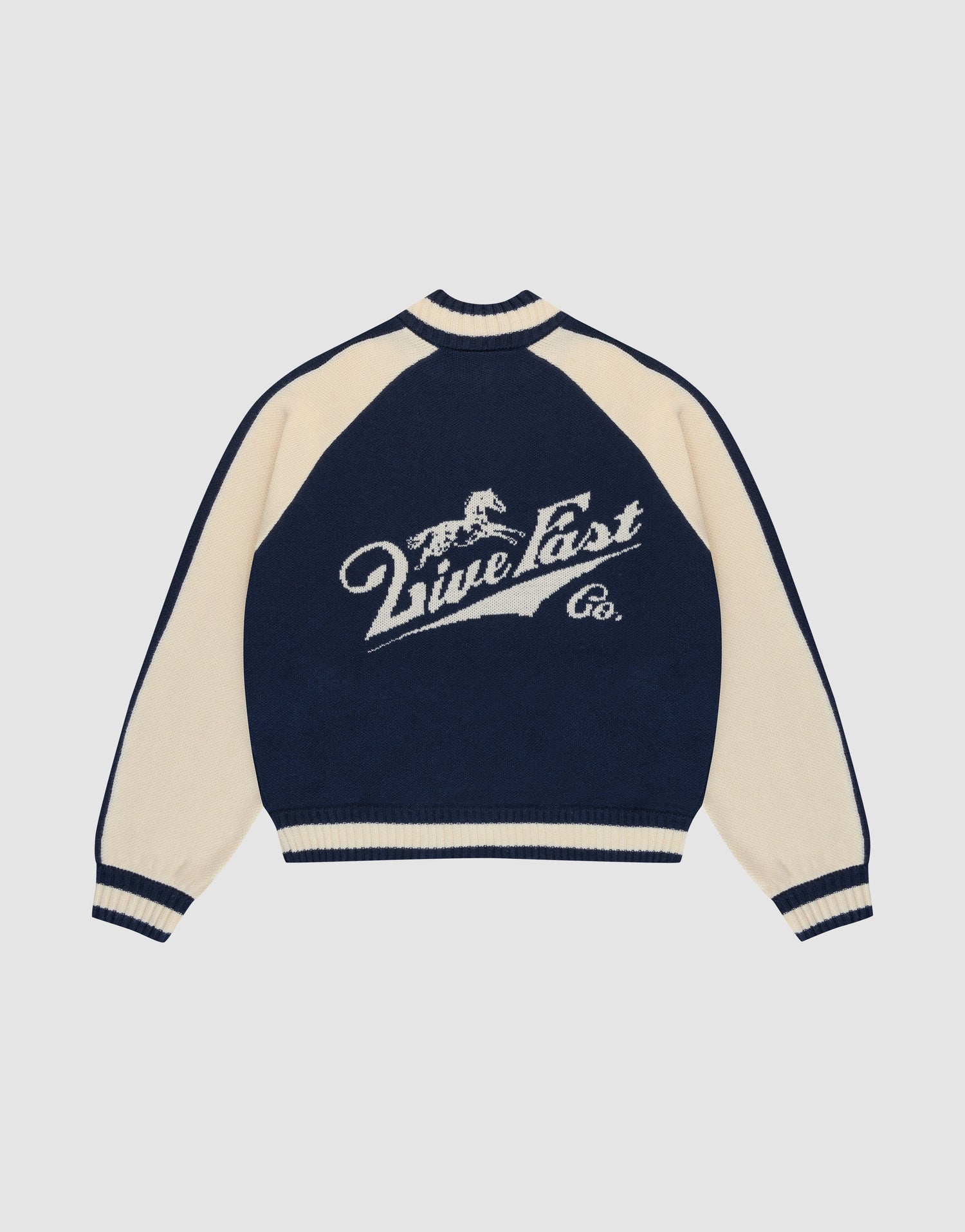 A navy blue and cream Boxy Knit Zip Jacket by LIVE FAST DIE YOUNG, with oversized fit, long raglan sleeves, and a large intarsia-knit running horse graphic above "Live Fast Co." script on the back.