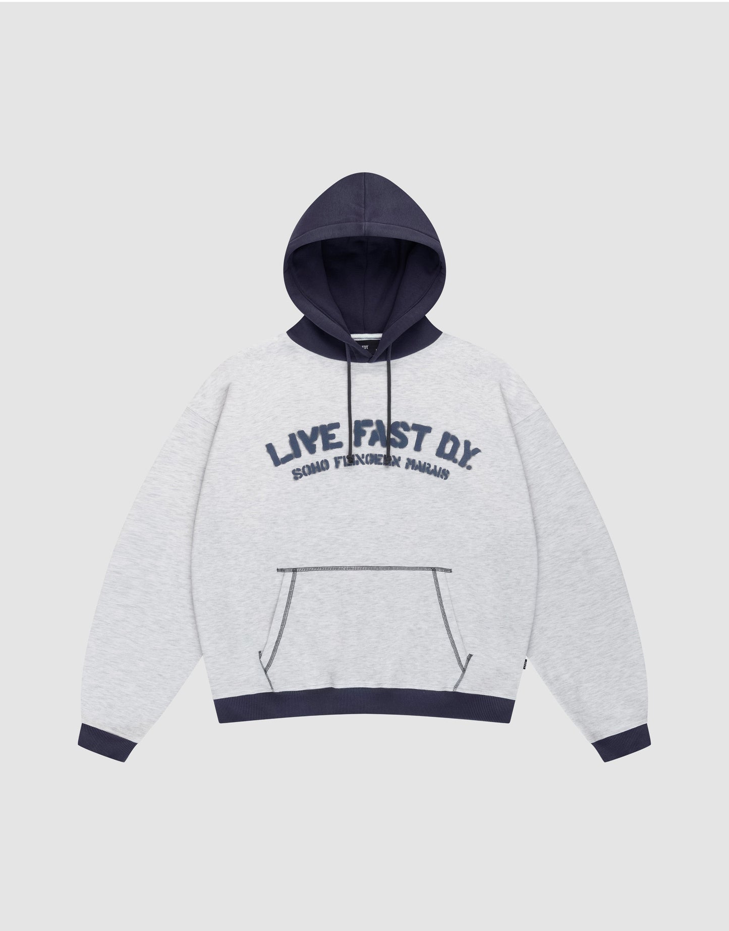 The LFDY District Hooded by LIVE FAST DIE YOUNG features a light gray oversize fit, dark blue contrast hood, cuffs, and hem. Front print: "LIVE FAST D.I.Y." with "BOARD FINGERS PALMS" below. Includes a kangaroo pocket.