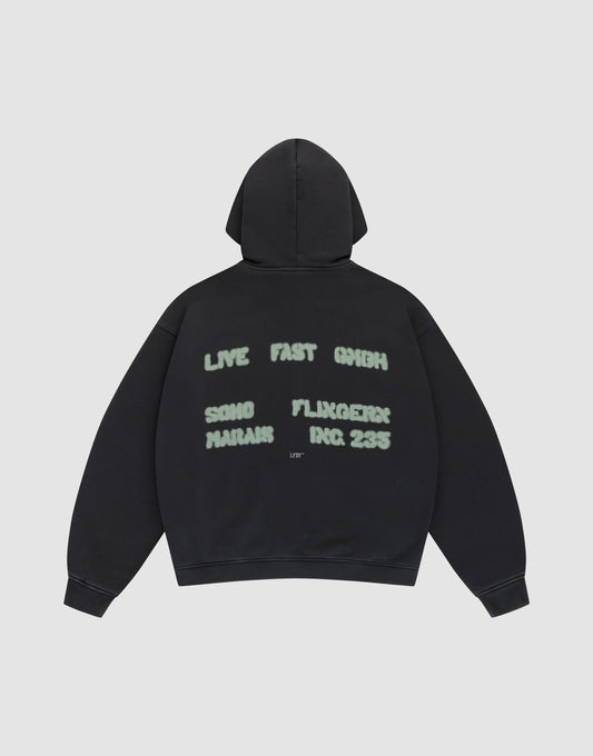The Live Fast District Hooded Zip by LIVE FAST DIE YOUNG features an oversized black fit with light green spray-painted style text—LIVE FAST 6HIGH, SONG MARJAN, FLUXGEIST, INC. 235—and subtle LFDY branding on the back, shown flat on a plain light background. | plain