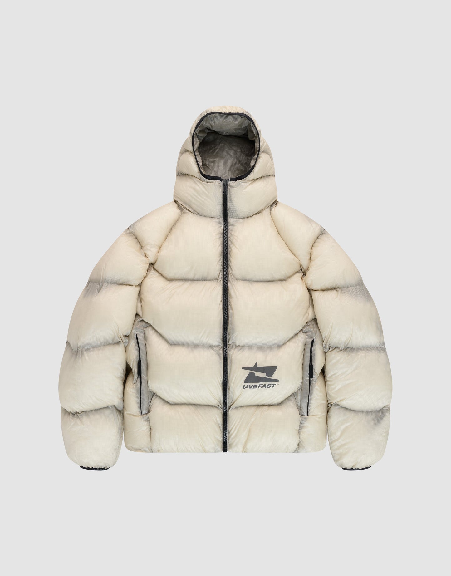 The Live Fast Puffer Jacket by LIVE FAST DIE YOUNG is cream-colored, oversize fit, with a hood, front zipper, two side pockets, and LIVE FAST logo plus reflective graphic prints on front and back. Shaded edges add a distinctive touch.