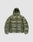 The Live Fast Puffer Jacket by LIVE FAST DIE YOUNG is an olive green, shiny nylon jacket with an oversized fit, hood, front zipper, large horizontal quilting, and a small white "LIVE FAST" logo on the lower left front. Displayed on light gray.