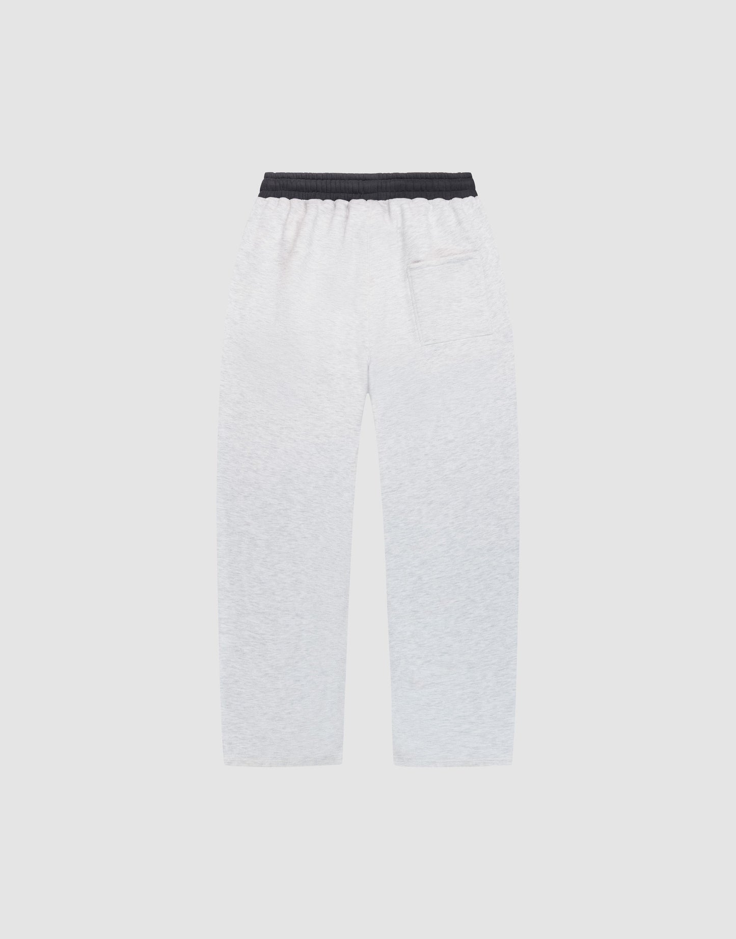 The LFDY District Jogger by LIVE FAST DIE YOUNG, featuring wide-fit white sweatpants with 65% cotton, a black elastic waistband, side pockets, and a back patch pocket, is displayed flat on a plain light gray background.