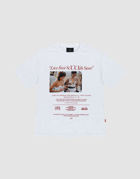 The LFDY SiXXXth Store Tee by LIVE FAST DIE YOUNG is an oversize white t-shirt with a vintage-style photo of two women laughing, the red “Live Fast SiXXth Store” logo above, red text below, and made from 100% Baumwolle.