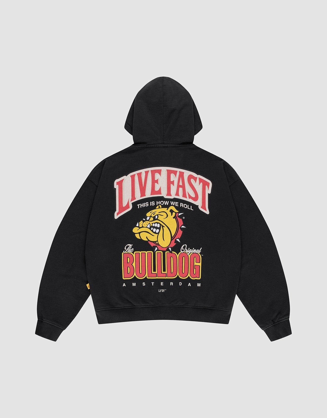 The LFDY x The Bulldog Hooded Zip by LIVE FAST DIE YOUNG is a black oversized cotton pullover with a bold bulldog back graphic, LIVE FAST text, and "This is how we roll, The Original Bulldog, Amsterdam" logo print.