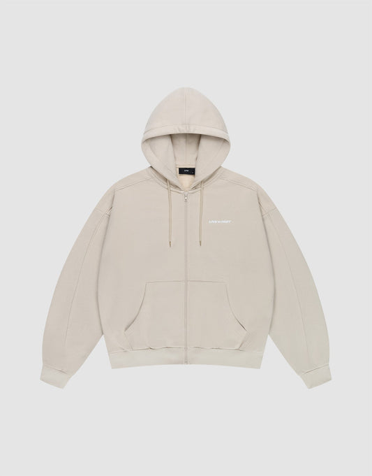 The LFDY Pleated Hooded Zip by LIVE FAST DIE YOUNG is a light beige oversized zip-up hoodie with a drawstring hood, front pockets, and small white logo on the chest. Made from 100% cotton and shown against a plain white background. | plain