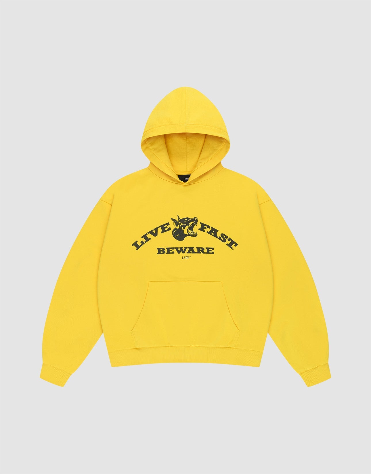 The Live Fast Beware Hooded by LIVE FAST DIE YOUNG is an oversize yellow hoodie made of 100% Baumwolle, featuring black "LIVE FAST. BEWARE" text and a horned skull illustration on the chest, set against a light gray background.| plain