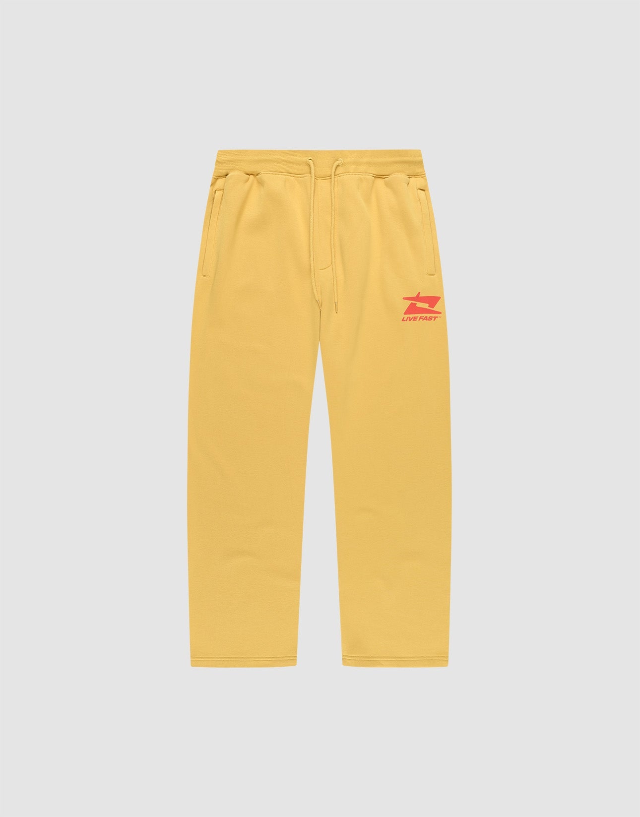 The LIVE FAST DIE YOUNG Live Fast Sweatsuit Jogger features yellow wide-fit sweatpants with side pockets, an elastic drawstring waist, and red LIVE FAST text plus graphic on the left thigh, shown on a plain light grey background.