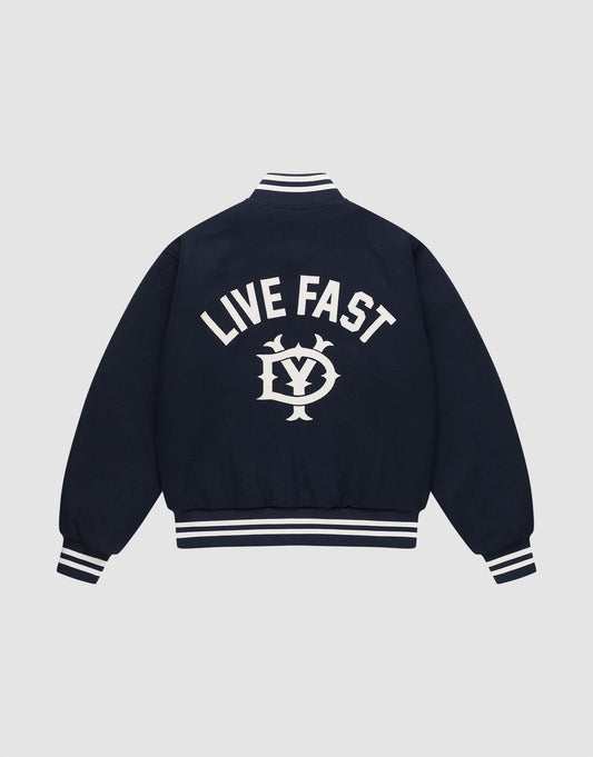 The Live Fast College Jacket by LIVE FAST DIE YOUNG is a navy varsity jacket with white striped cuffs, collar, and hem. The back features bold "LIVE FAST" Rückenstick text above an LV circular emblem. Regular fit for comfort and style. | plain