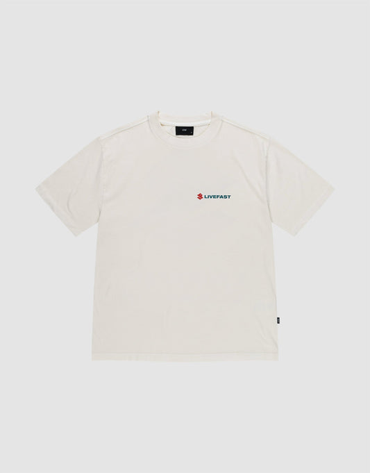The LFDY Dealership Tee by LIVE FAST DIE YOUNG is an oversized, plain white 100% cotton short-sleeve T-shirt with a small blue and red LIVEFAST graphic on the left chest, shown against a light gray background.