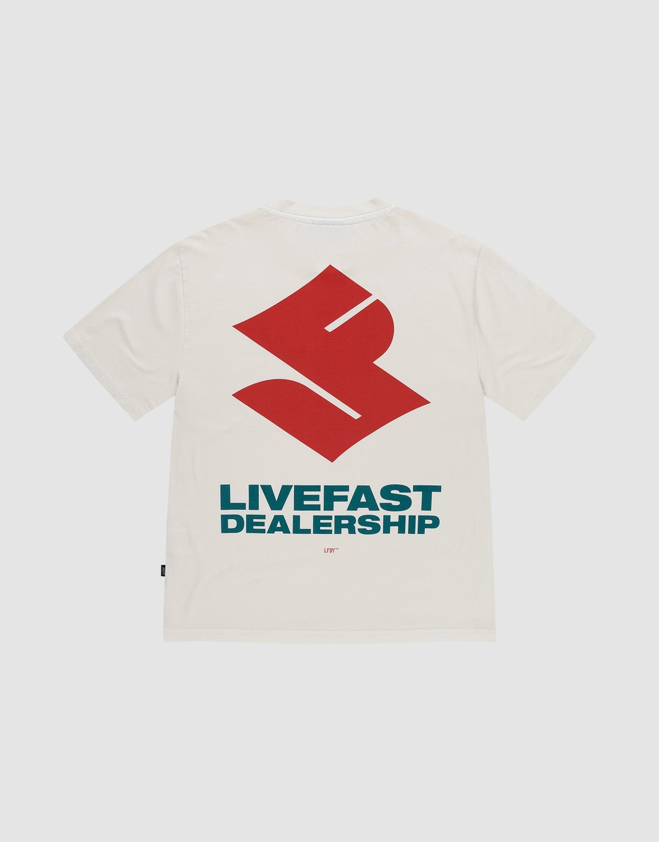 The LFDY Dealership Tee by LIVE FAST DIE YOUNG is an oversized white 100% cotton t-shirt, featuring a large red geometric backprint above bold blue "LIVEFAST DEALERSHIP" text and a small "LFTF" below, shown on a plain background. | plain