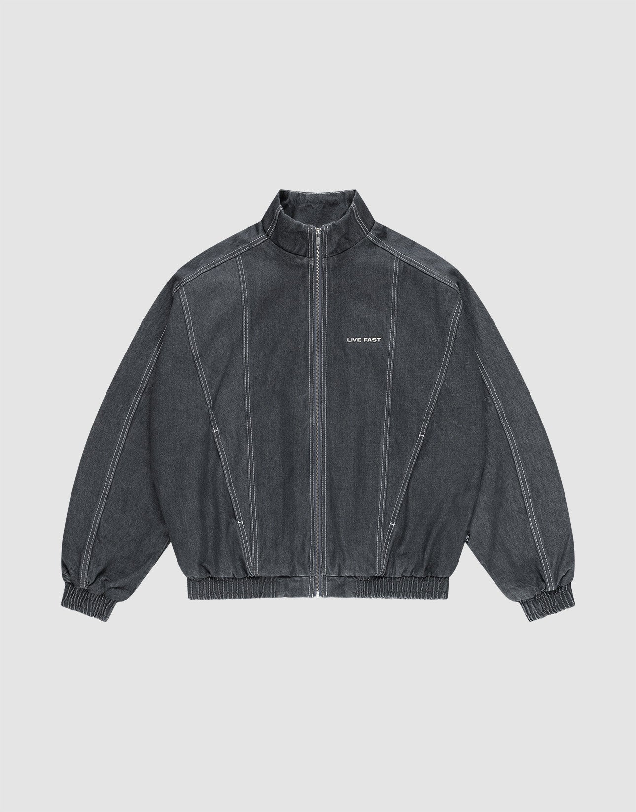 The LFDY Denim Trackjacket by LIVE FAST DIE YOUNG is dark gray, 100% Baumwolle, with a front zipper, stand collar, elastic cuffs and hem, white seams, and "LIFE PAINT" in white text on the left chest. Shown laid flat on a light background. | plain