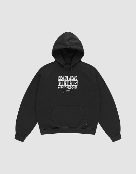 The Live Fast Call Us Hooded by LIVE FAST DIE YOUNG is a black Baumwolle hoodie with Oversize Fit, front pocket, and a white BEACH VIEWS FOR FRIENDS +49 17-5566-3407 print on the chest, shown on a plain light gray background.